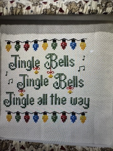 Kathy&rsquo;s finished cross-stitch: Jingle Bells, with strings of Christmas lights